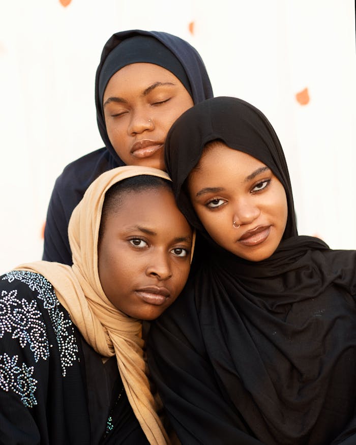 Three women in hijabs showing unity and diversity in a close-up portrait.